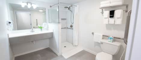 A modern bathroom with a shower, toilet, and vanity.