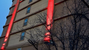 A tall hotel building with a prominent red vertical sign reading "MEADOWLAZOS" and "AZA HOTEL" on the facade.
