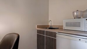 Eine kompakte Küchenzeile mit Mikrowelle, Spüle und Kühlschrank.