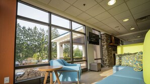 A modern interior with large windows, a stone wall, and seating areas. - Hampton Inn Clarks Summit (Clarks Summit)