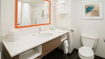 Une salle de bain avec un lavabo blanc, un miroir et des toilettes.