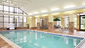 An indoor swimming pool with clear water, surrounded by lounge chairs and a covered seating area. - Hampton Inn Clarks Summit (Clarks Summit)