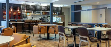A modern cafe with multiple seating areas, a bar, and a visible Starbucks logo.
