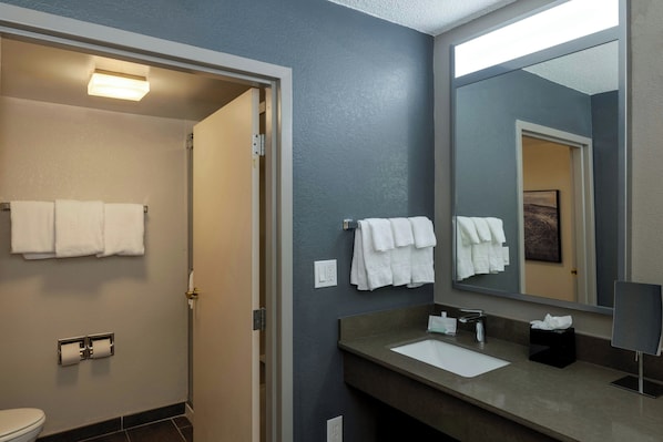 Un baño con lavabo, espejo y toallas.
