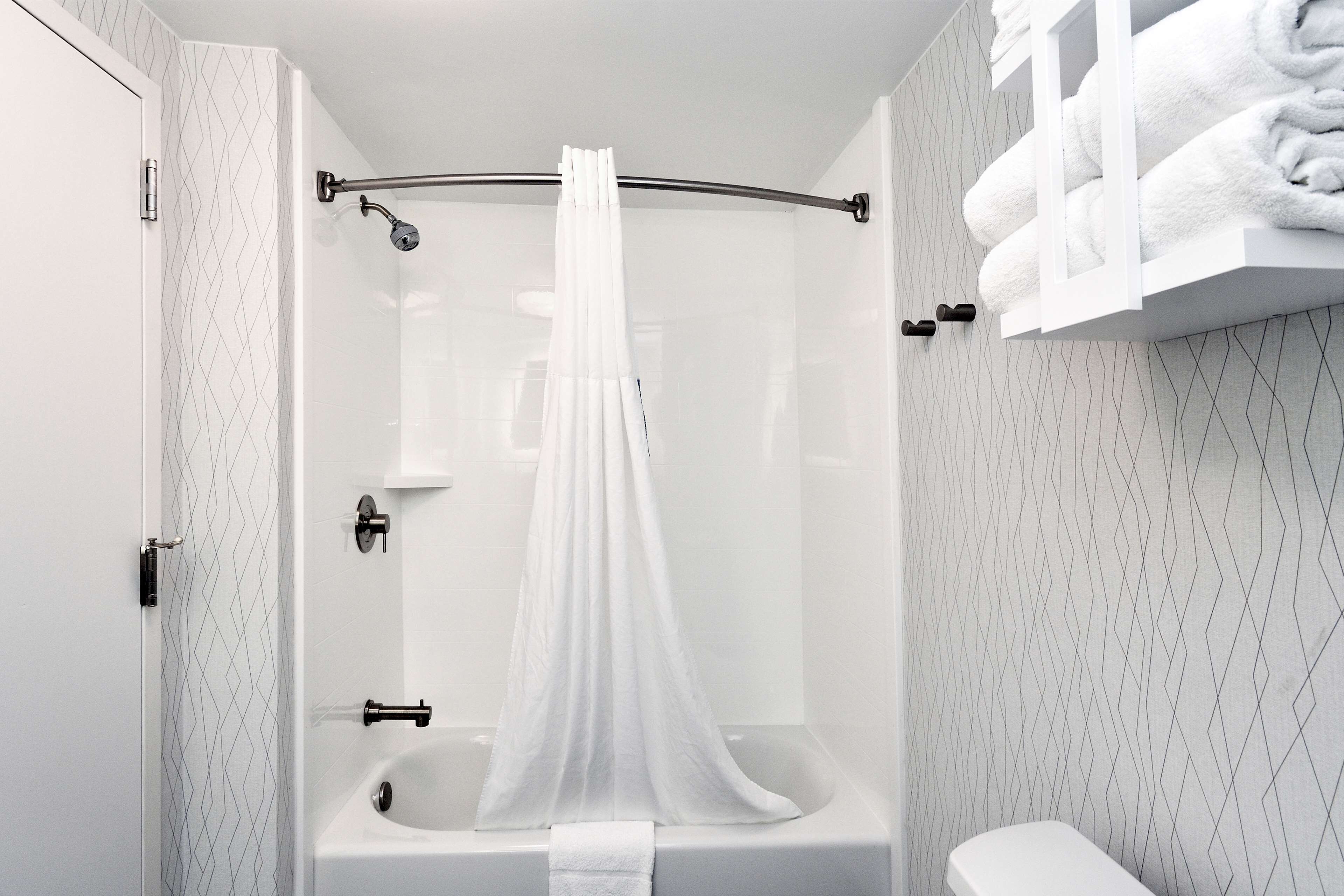 A modern bathroom with a glass-enclosed shower, a bathtub, and a toilet.