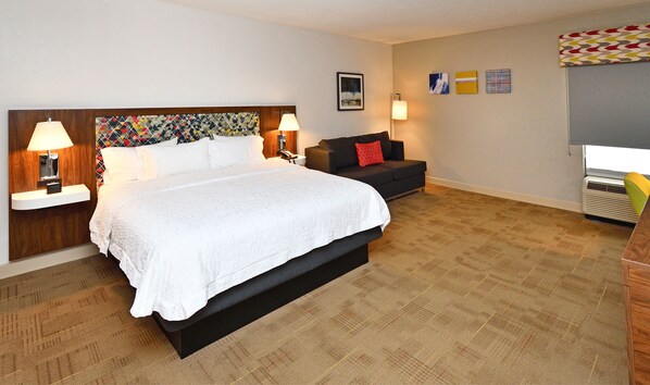 A hotel room with a large bed, bedside lamps, a sofa, and a small table. - Hampton Inn Santee-I-95 (Santee)