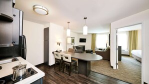 Une chambre d’hôtel moderne dotée d’une kitchenette, d’un coin repas et d’une chambre à coucher.
