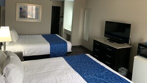 A hotel room with two beds, a TV, a dresser, and a painting on the wall. - Baymont by Wyndham Enid (Enid)