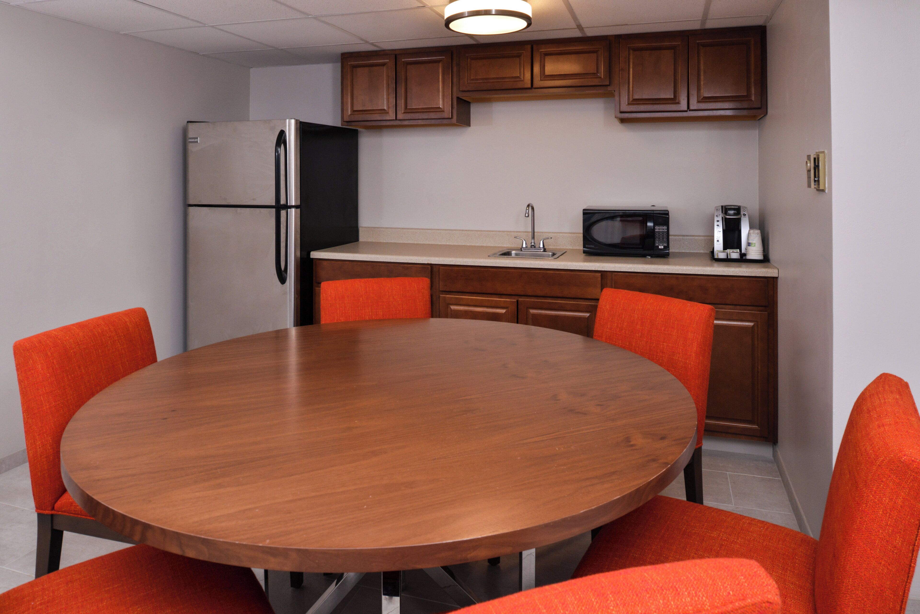 A compact kitchen with a refrigerator, microwave, and coffee maker.