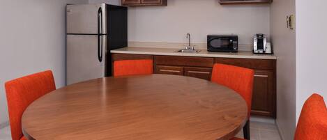A compact kitchen with a refrigerator, microwave, and coffee maker.