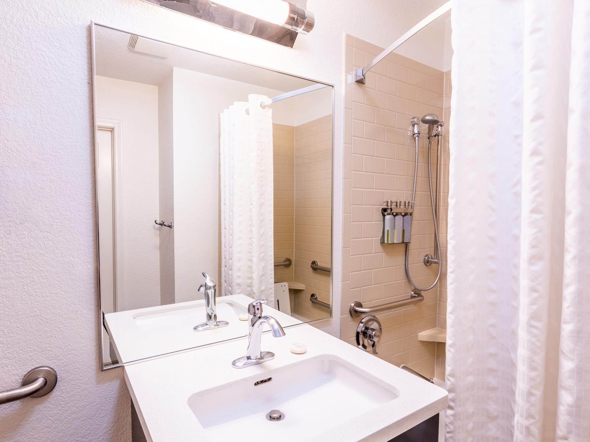 Un baño con dos lavamanos, un espejo y una ducha.