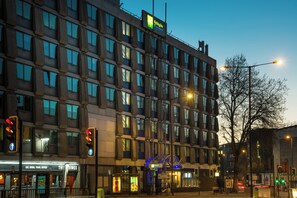 Un hôtel à plusieurs étages doté d’une architecture moderne et arborant une enseigne Holiday Inn Express bien visible.