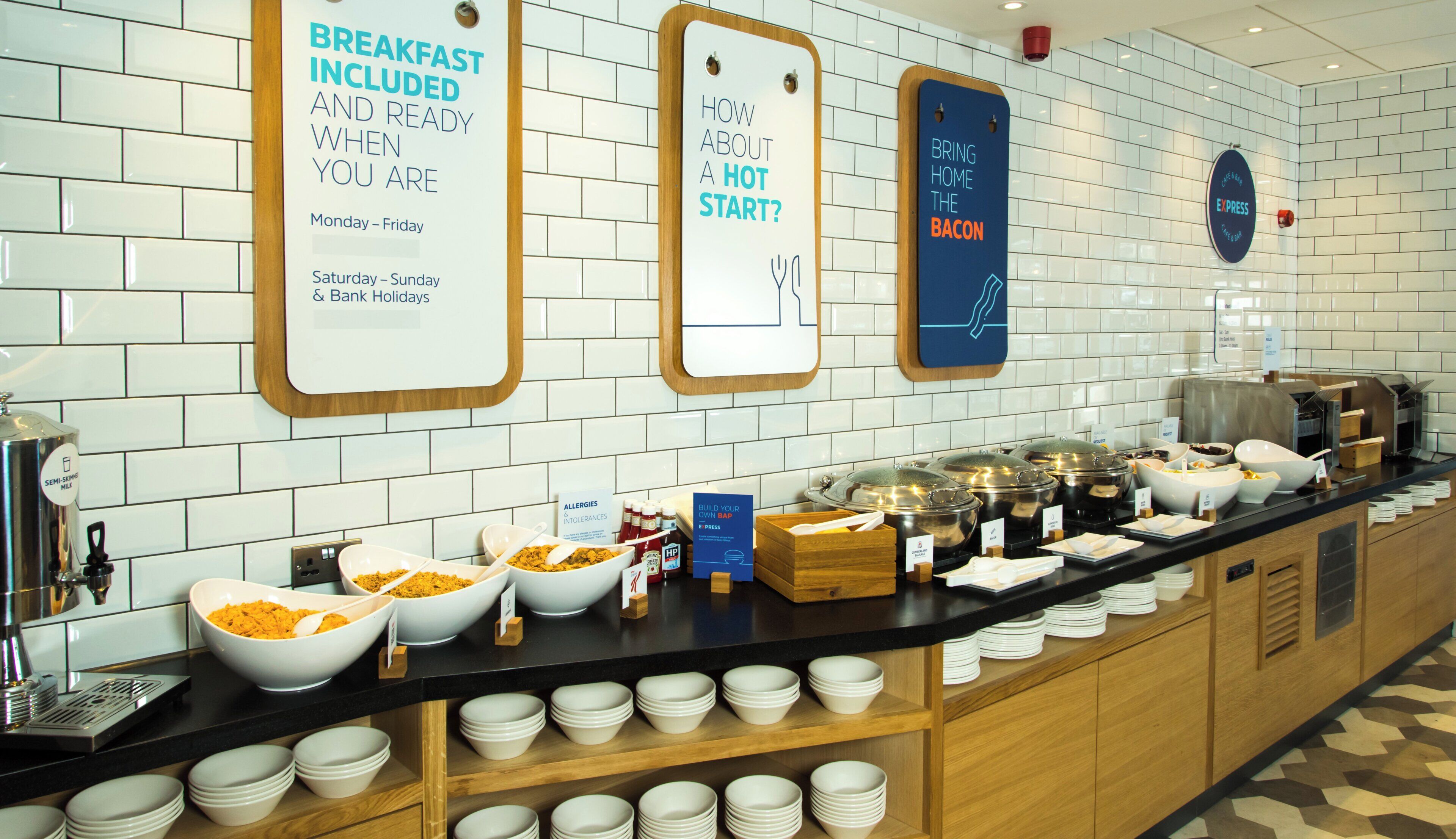 A breakfast buffet with various food items and a sign indicating breakfast is included and ready when you are.