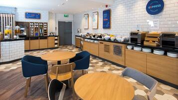 A cafe area with a breakfast bar, seating, and a sign indicating breakfast is included.