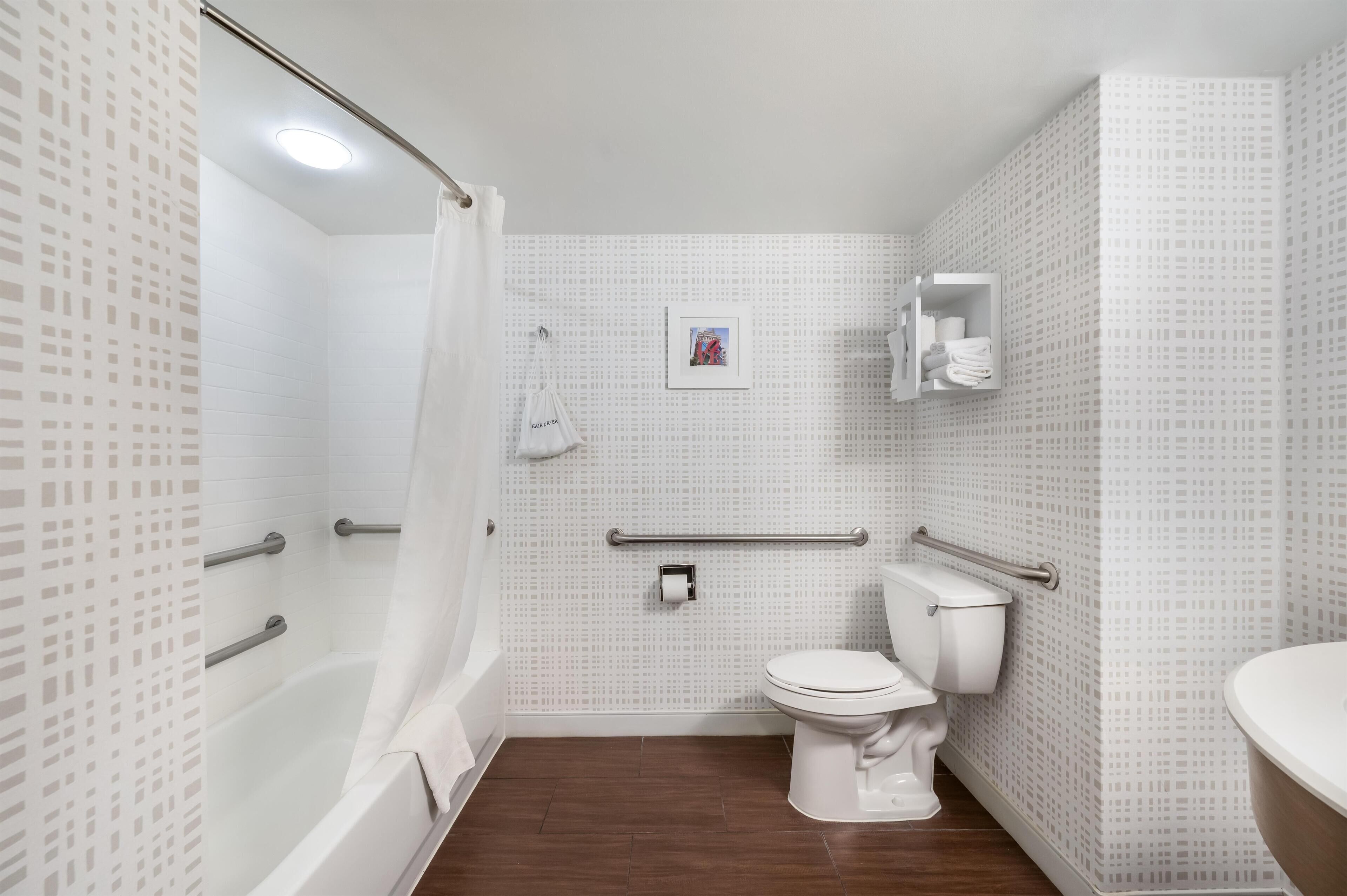 A bathroom with a shower, toilet, and sink.