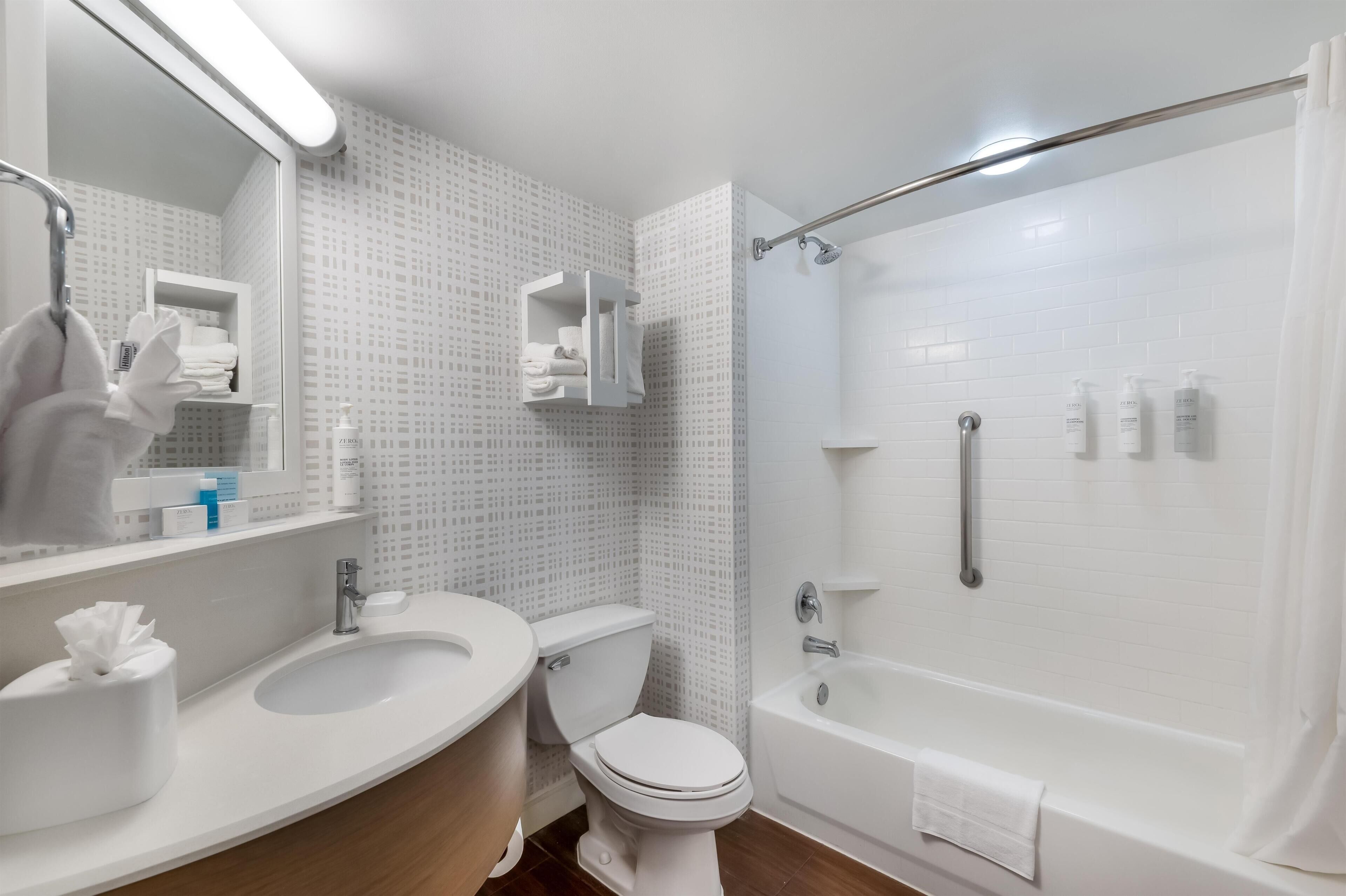 A bathroom with a sink, toilet, and shower.
