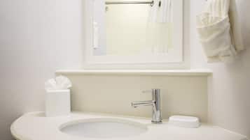Une salle de bain avec un lavabo blanc, un miroir et un porte-serviettes.