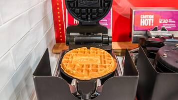 A waffle maker with a waffle inside, a caution sign, and a time limit sign.