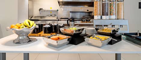 A buffet setup with various food items and condiments.