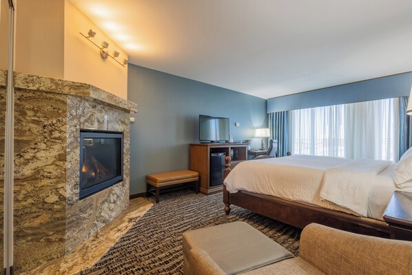 Een hotelkamer met een stenen openhaard, een bed, een bureau en een televisie.