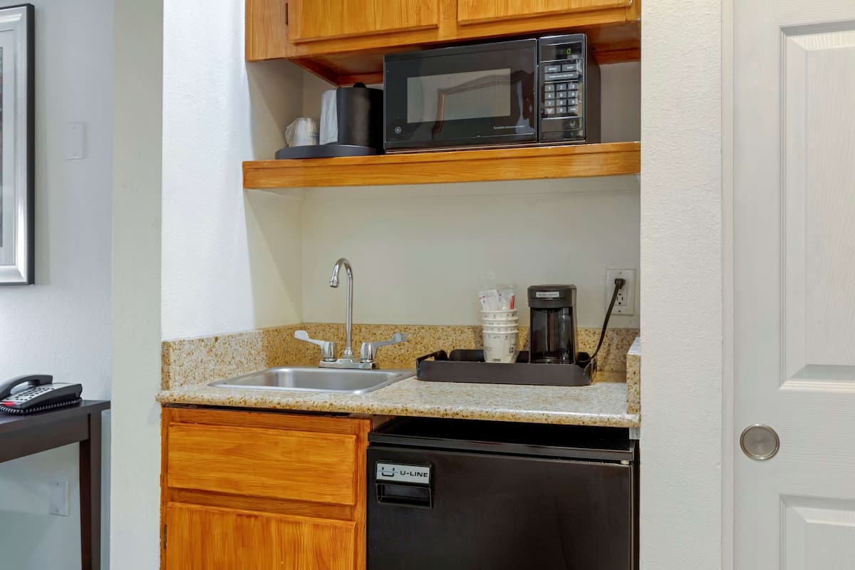 A compact kitchen with a microwave, coffee maker, and dishwasher.