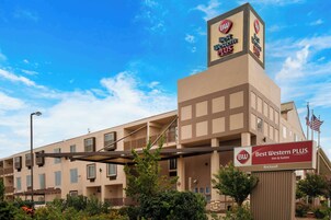 Un hotel Best Western PLUS con un letrero llamativo, varios balcones y una bandera.