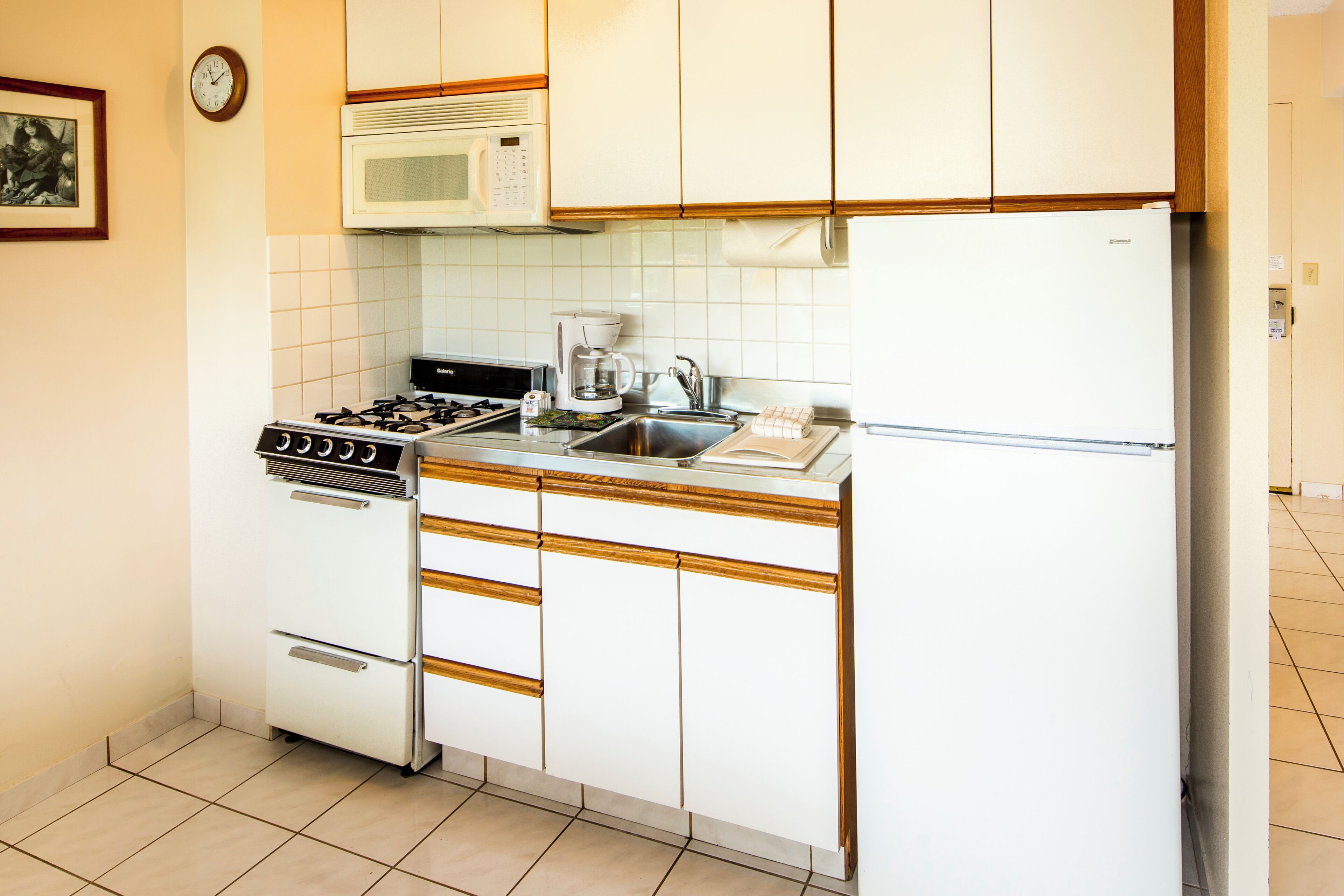 Une cuisine compacte équipée d’une cuisinière, d’un four à micro-ondes et d’un réfrigérateur.