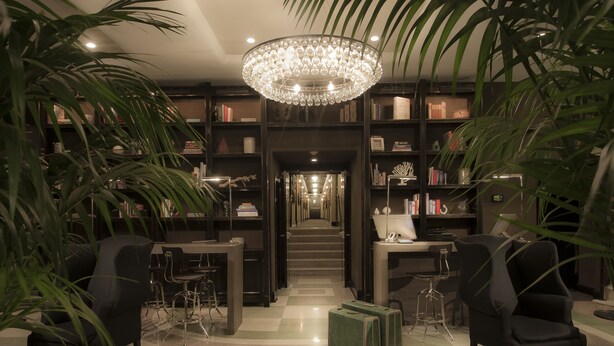 A library with bookshelves, a chandelier, and seating areas. - The Shepley South Beach Hotel (Miami Beach)
