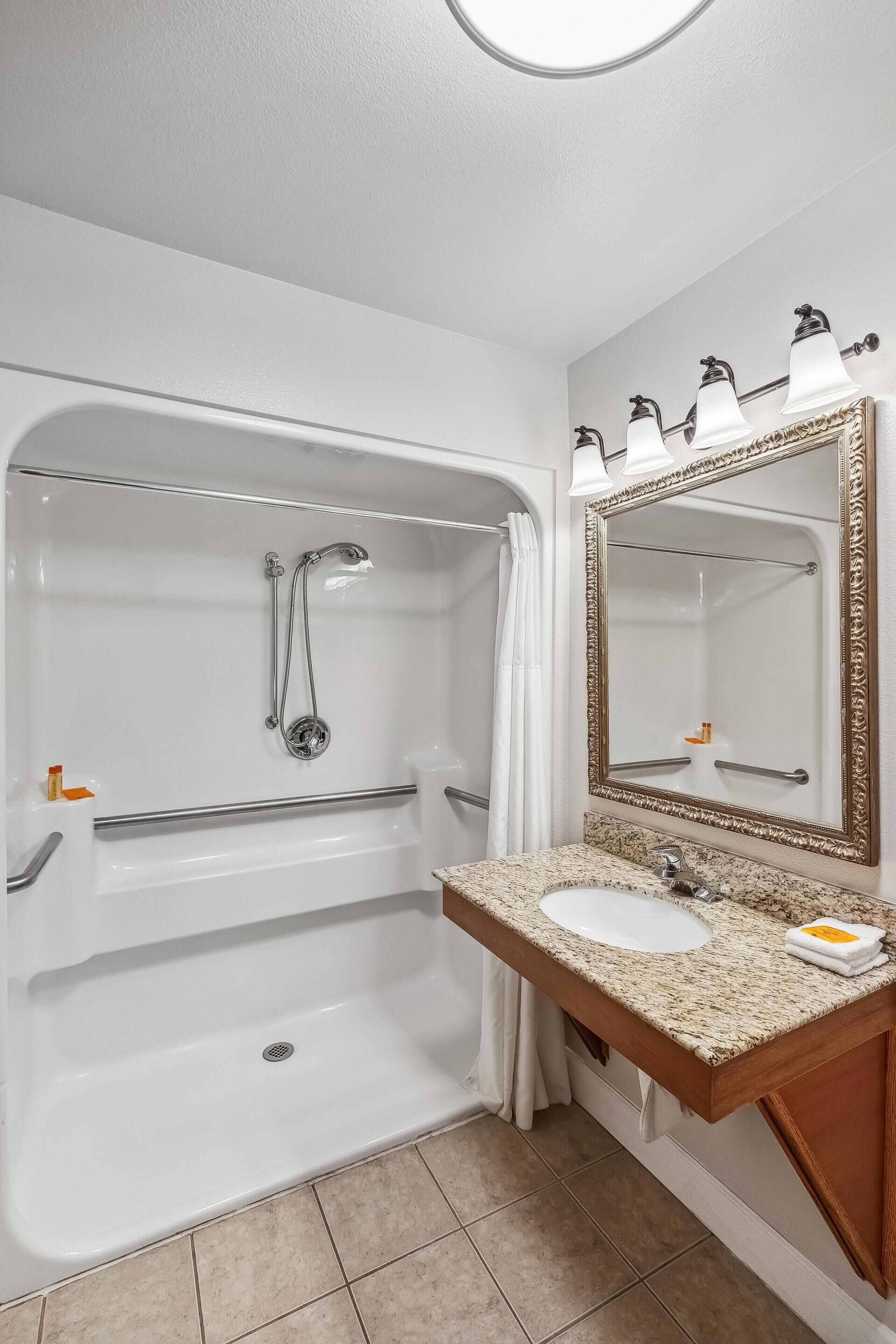 Un baño con bañera, lavabo, espejo y cortina de ducha.