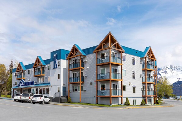 A multi-story hotel with a modern architectural design, featuring balconies and a prominent blue roof. - Hotel Edgewater (Seward)