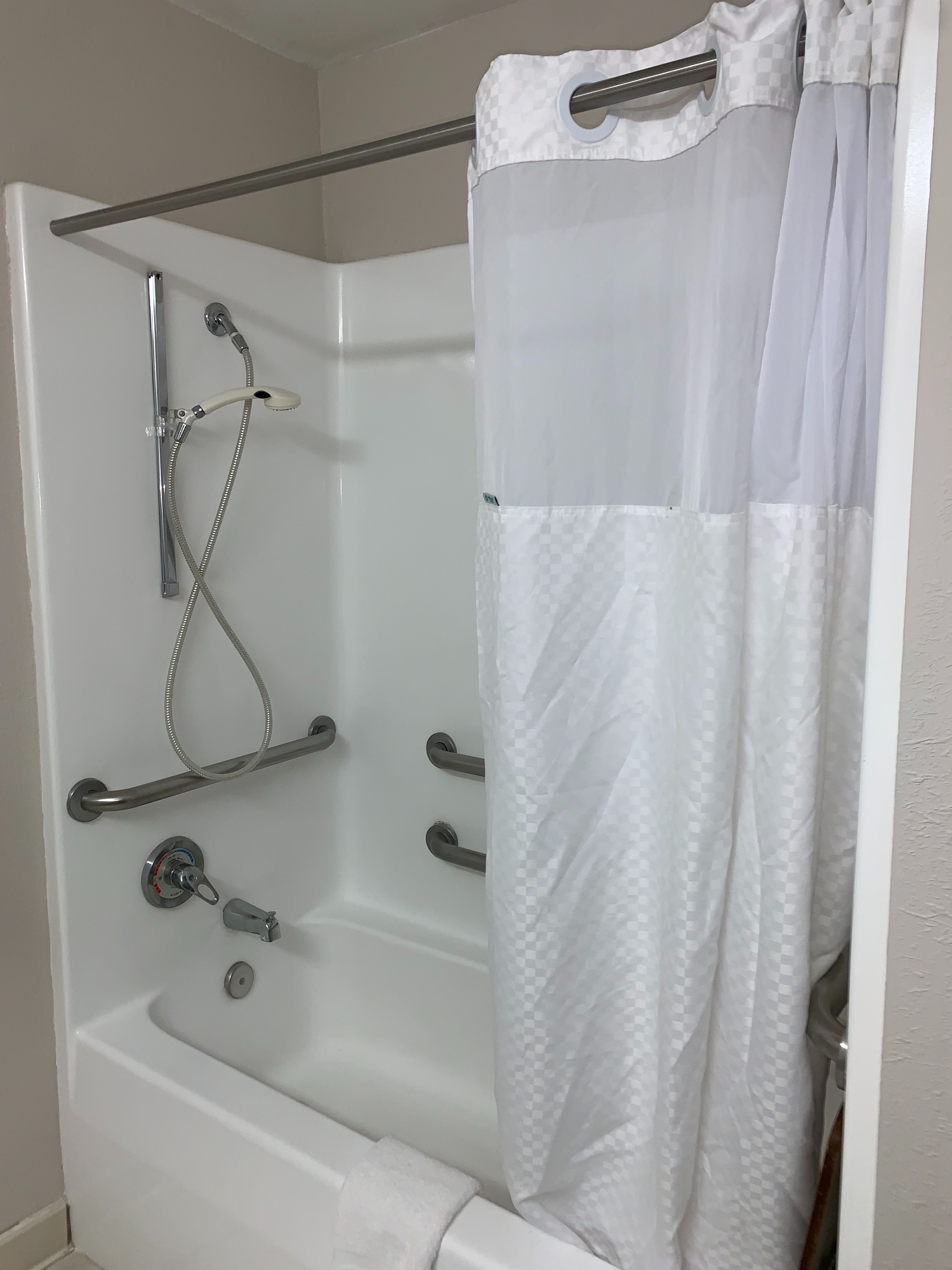 Un baño con bañera, ducha y un perchero para toallas.