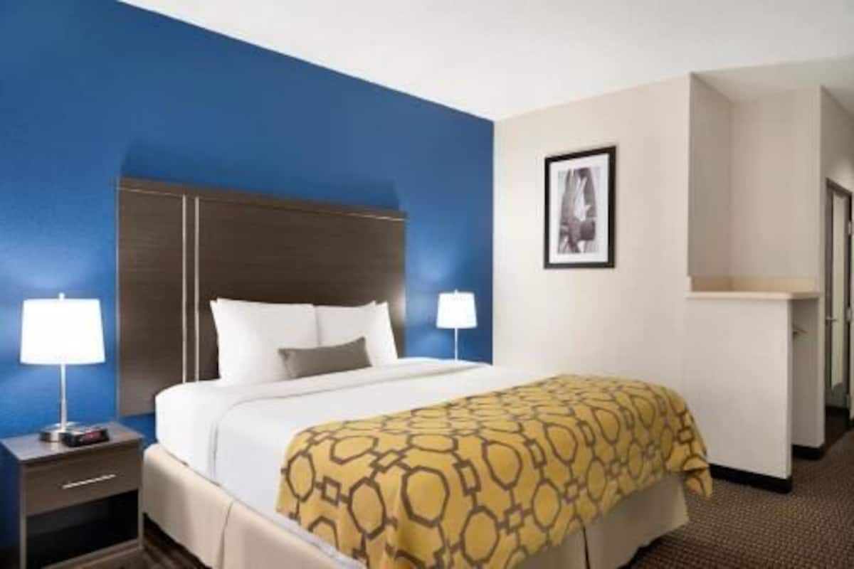 Escritorio, cortinas blackout y tabla de planchar con plancha