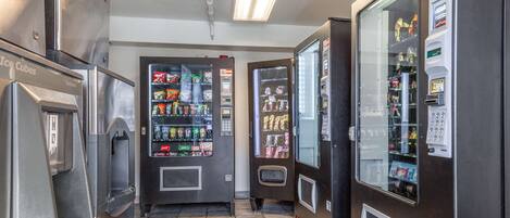A vending area with various machines, including a beverage dispenser and a refrigerator.