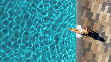 Een buitenzwembad, zwembadcabana's (toeslag) en ligstoelen