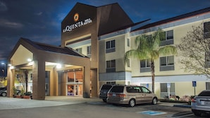Un hotel de diseño moderno, con una entrada destacada que cuenta con un área cubierta y un letrero que dice "La Quinta Inn & Suites".