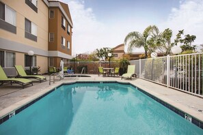 Una piscina al aire libre, tumbonas