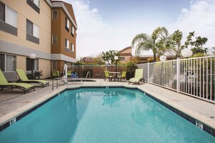 Una piscina al aire libre, sillones reclinables de piscina