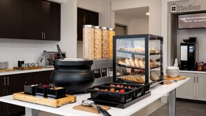 A breakfast buffet setup with various food items, a coffee machine, and a sign indicating specialty coffee. - Hilton Garden Inn Folsom (Folsom)