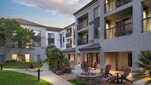 A multi-story residential building with balconies, outdoor seating, and a landscaped garden area. - Courtyard by Marriott Milpitas Silicon Valley (Milpitas)