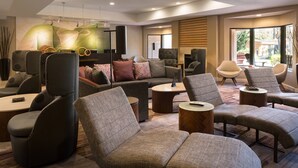 A modern lounge area with sofas, armchairs, and a coffee table. - Courtyard by Marriott Milpitas Silicon Valley (Milpitas)