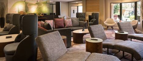 A modern lounge area with sofas, armchairs, and a coffee table.