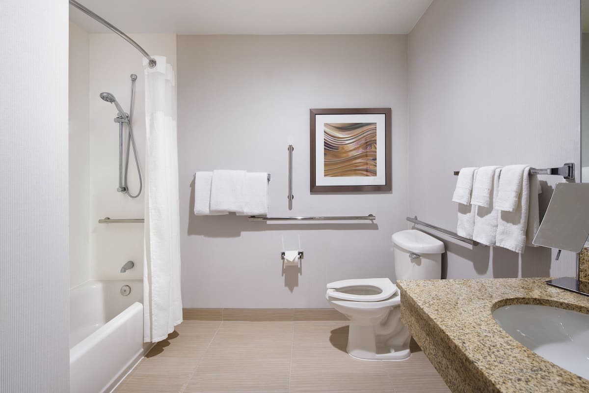 A modern bathroom with a bathtub, toilet, and sink.