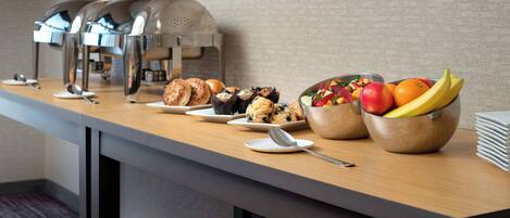 A buffet table with various food items and a coffee station.