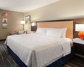A hotel room with a large bed, a nightstand, a lamp, and a wall-mounted TV. - Hampton Inn Tracy (Tracy)