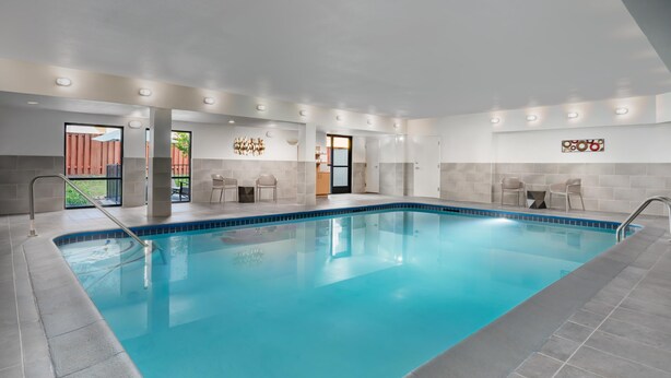 An indoor swimming pool with a clear blue water, tiled walls, and a modern design. - Hampton Inn Tracy (Tracy)