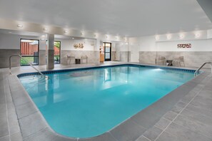 An indoor swimming pool with a clear blue water, tiled walls, and a modern design.