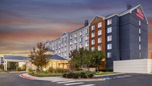 A modern hotel with a prominent "Hilton Garden Inn" sign, a well-maintained parking area, and a landscaped entrance.
