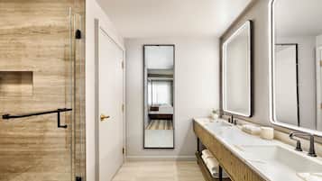 A modern bathroom with a glass shower enclosure, a wooden vanity, and a large mirror.