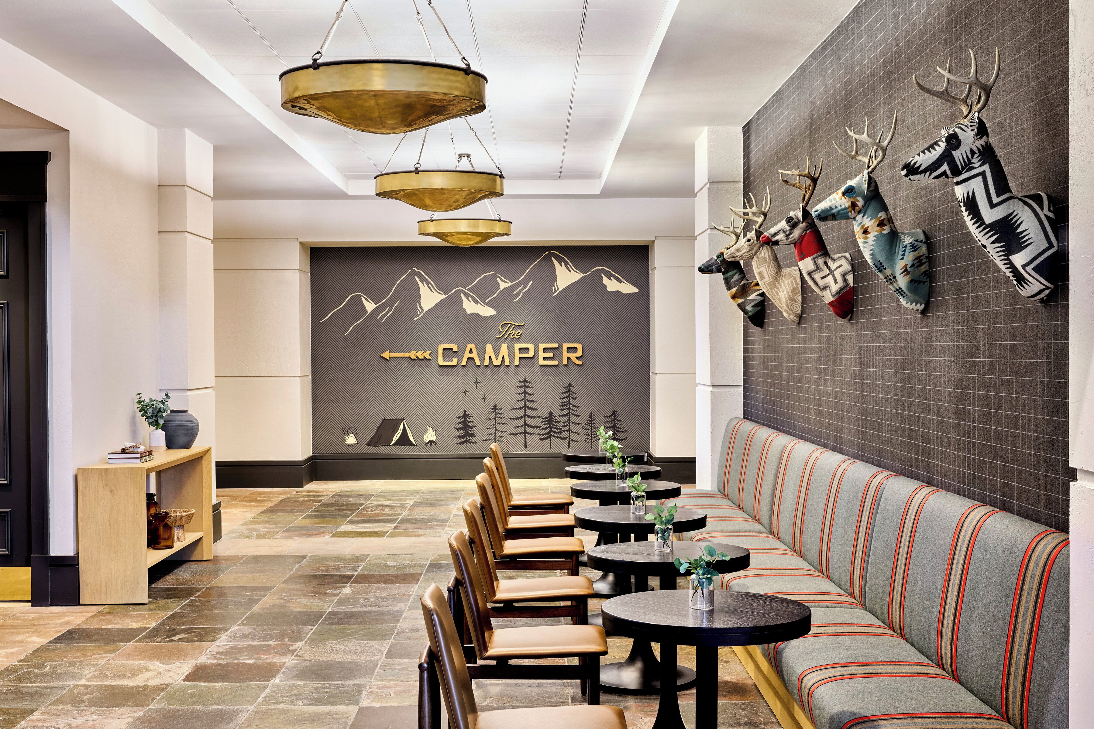 A modern interior with a seating area, tables, and a wall with mounted animal heads.