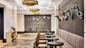 A modern interior with a seating area, tables, and a wall with mounted animal heads.